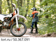 stylish rider with motorbike parked forrest. Стоковое фото, агентство Ingram Publishing / Фотобанк Лори