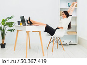 woman stretching arms sitting table office. Стоковое фото, агентство Ingram Publishing / Фотобанк Лори