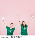 excited man woman with smartphone raising their arms. Стоковое фото, агентство Ingram Publishing / Фотобанк Лори