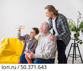 men different generations looking toy plane. Стоковое фото, агентство Ingram Publishing / Фотобанк Лори