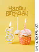 birthday cupcake with lit candle. Стоковое фото, агентство Ingram Publishing / Фотобанк Лори