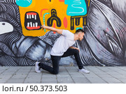breakdancer dancing painted wall background. Стоковое фото, агентство Ingram Publishing / Фотобанк Лори