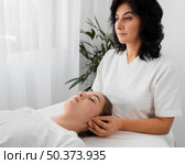 female osteopathist treating patient indoors. Стоковое фото, агентство Ingram Publishing / Фотобанк Лори
