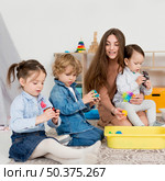 woman playing with children with rubik s cube. Редакционное фото, агентство Ingram Publishing / Фотобанк Лори