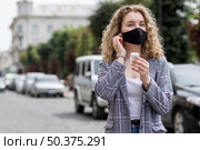 woman with mask outdoor with airpods. Стоковое фото, агентство Ingram Publishing / Фотобанк Лори