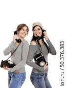 Two young women talking with old telephones - Isolated on white. Стоковое фото, агентство Ingram Publishing / Фотобанк Лори