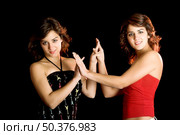 Two young beautiful sisters giving the hands and having fun - This models are true twins. Стоковое фото, агентство Ingram Publishing / Фотобанк Лори