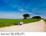 Beautiful young woman hitch hiking with old leather suitcase, isolated on white. Стоковое фото, агентство Ingram Publishing / Фотобанк Лори