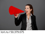 Business young woman speaking to a megaphone, over a grey background. Стоковое фото, агентство Ingram Publishing / Фотобанк Лори