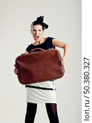 Portrait of a beautiful fashion woman posing and holding a old suitcase. Стоковое фото, агентство Ingram Publishing / Фотобанк Лори