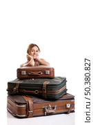 Beautiful and happy young woman behind the baggage, isolated on white background. Стоковое фото, агентство Ingram Publishing / Фотобанк Лори