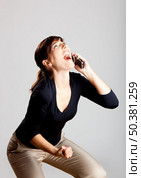 Portrait of a beautiful woman making a phone call and very happy with the good news. Стоковое фото, агентство Ingram Publishing / Фотобанк Лори