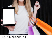 girl with shopping bags holding tablet mock up. Стоковое фото, агентство Ingram Publishing / Фотобанк Лори
