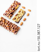 OLYMPUS DIGITAL CAMERA. healthy cereal almonds bars against white background. Стоковое фото, агентство Ingram Publishing / Фотобанк Лори
