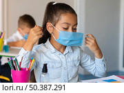 little girl putting face mask. Стоковое фото, агентство Ingram Publishing / Фотобанк Лори