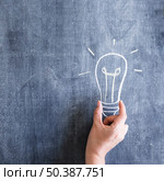 person holding light bulb drawn chalkboard. Стоковое фото, агентство Ingram Publishing / Фотобанк Лори