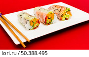 steamed spring rolls arrange white plate with chopstick red surface. Стоковое фото, агентство Ingram Publishing / Фотобанк Лори