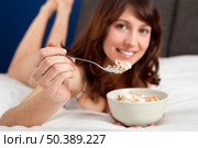 Beautiful and healthy young woman eating a cup of cereals with yogurt. Стоковое фото, агентство Ingram Publishing / Фотобанк Лори