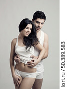 Beautiful and attractive young couple in underwear standing over a white background. Стоковое фото, агентство Ingram Publishing / Фотобанк Лори