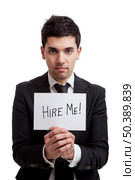 Businessman holding a cardboard with the text Hire Me, isolated on white background. Стоковое фото, агентство Ingram Publishing / Фотобанк Лори