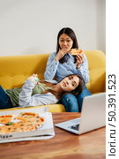 chilling girls watching movie eating pizza. Стоковое фото, агентство Ingram Publishing / Фотобанк Лори