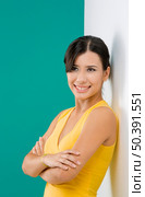 Beautiful and happy asian woman against a white wall in a green background. Стоковое фото, агентство Ingram Publishing / Фотобанк Лори