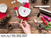 elevated view woman s hand holding santa claus prop table. Стоковое фото, агентство Ingram Publishing / Фотобанк Лори
