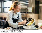 female chef pouring food plate. Стоковое фото, агентство Ingram Publishing / Фотобанк Лори