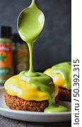 A close-up of a spoonful of matcha-infused hollandaise sauce drizzling over eggs Benedict, green and yellow hues contrasting beautiful kitchen background. Стоковое AI-видео, аниматор Sergey Grishin / Фотобанк Лори