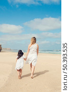 Beautiful pregnant woman and her little daughter walking on the beach. Стоковое фото, агентство Ingram Publishing / Фотобанк Лори