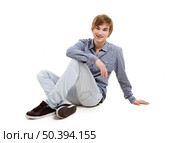 Happy young man sitting on the floor, over a white background. Стоковое фото, агентство Ingram Publishing / Фотобанк Лори