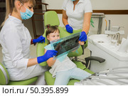 dentist girl patient looking radiography. Стоковое фото, агентство Ingram Publishing / Фотобанк Лори