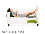 Beautiful woman on a sofa with a cellphone texting, isolated in white. Стоковое фото, агентство Ingram Publishing / Фотобанк Лори