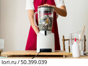 midsection view woman grinding pieces paper blender. Стоковое фото, агентство Ingram Publishing / Фотобанк Лори