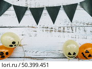 triangle dark flags hanging balloons with creepy faces wooden background. Стоковое фото, агентство Ingram Publishing / Фотобанк Лори