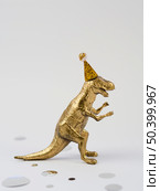 OLYMPUS DIGITAL CAMERA. lateral view golden toy t rex. Стоковое фото, агентство Ingram Publishing / Фотобанк Лори