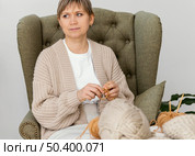 medium shot woman knitting looking away. Стоковое фото, агентство Ingram Publishing / Фотобанк Лори