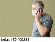 bearded man with surgical mask using phone 2. Стоковое фото, агентство Ingram Publishing / Фотобанк Лори
