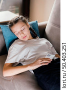 young girl holding mobile while asleep. Стоковое фото, агентство Ingram Publishing / Фотобанк Лори