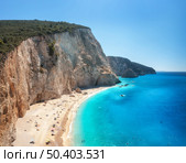 Aerial view of blue sea, rock, sandy beach at sunny day in summer. Famous Porto Katsiki, Lefkada island, Greece. Beautiful landscape with sea coast, swimming people, azure water. Top view. Travel. Стоковое фото, агентство Ingram Publishing / Фотобанк Лори
