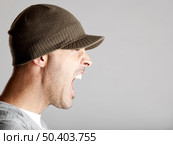 Profile portrait of a young man yelling, isolated on a gray background. Стоковое фото, агентство Ingram Publishing / Фотобанк Лори