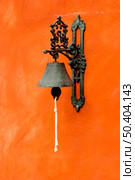 Old vintage bell on a orange wall. Стоковое фото, агентство Ingram Publishing / Фотобанк Лори