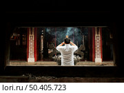 back view man praying temple with burning incense. Стоковое фото, агентство Ingram Publishing / Фотобанк Лори
