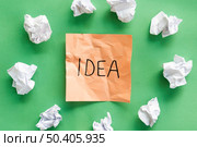 crumple paper around by orange adhesive note with idea text green background. Стоковое фото, агентство Ingram Publishing / Фотобанк Лори