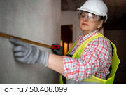 female construction worker with helmet tape measurer. Стоковое фото, агентство Ingram Publishing / Фотобанк Лори