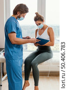 male osteopathic therapist with medical mask patient office signing clipboard. Стоковое фото, агентство Ingram Publishing / Фотобанк Лори