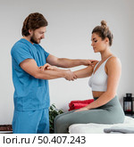 side view male osteopathic therapist checking female patient s shoulder. Стоковое фото, агентство Ingram Publishing / Фотобанк Лори