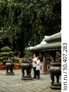 side view woman man praying temple with burning incense 2. Стоковое фото, агентство Ingram Publishing / Фотобанк Лори