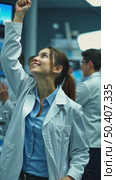 A young woman in a lab coat celebrates a breakthrough discovery, her right arm is raised in a fist pump. The background filled with happy colleagues making discovery. Стоковое AI-видео, аниматор Sergey Grishin / Фотобанк Лори
