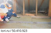 Insulation of a frame house with mineral wool. Cutting, fitting, laying insulation. Construction works. Стоковое видео, видеограф Константин Мерцалов / Фотобанк Лори